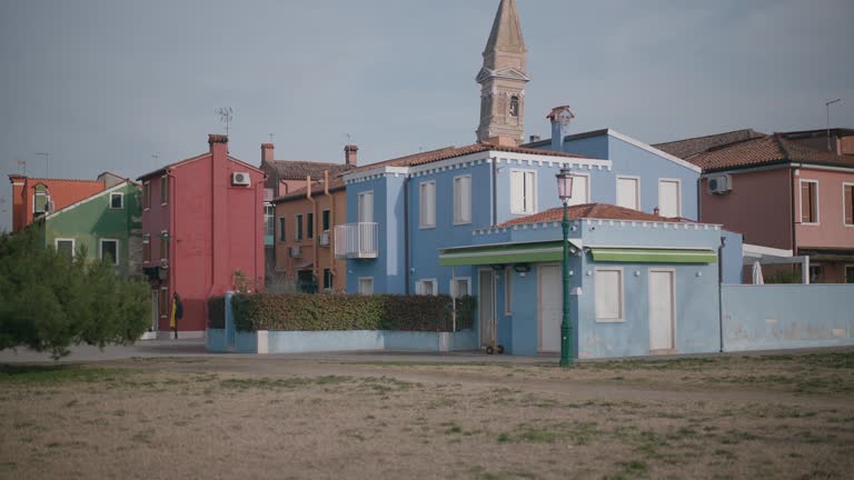 Burano's pastel houses under clear skies, Italy