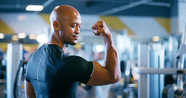 istock Fitness, arm flex and man in gym with confidence, growth and development in bicep exercise. Workout, challenge and strong athlete with health, wellness and muscle power with membership at sports club 2150096359