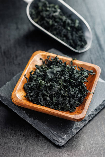 istock Dried wakame seaweed in bowl on black table. 2150097224