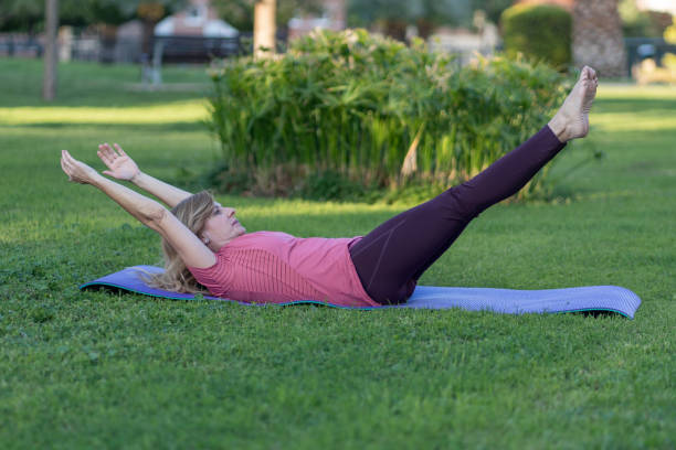 istock A woman is doing a yoga pose on a mat in a park 2150099006