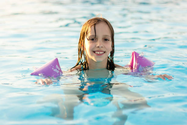 istock Girl in inflatable shoulder straps in the pool 2150099268