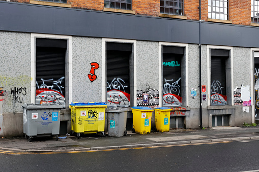View of a group of refuse bins in the centre of Manchester, UK.  There are no people in the photograph
