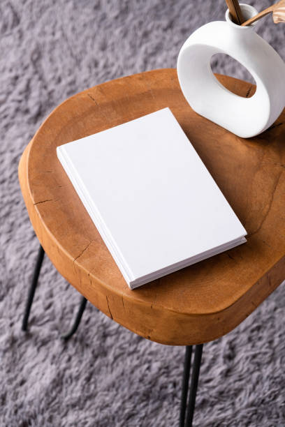 istock blank book mockup on coffee table with decorations and grey rug 2150100475