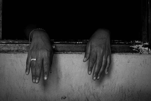A woman's hand is on the wooden window