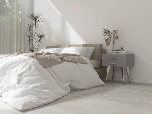 istock Modern, minimal white bedroom with beige bed, gray side table, dracaena tree in sunlight from window with sheer curtain 2150101120