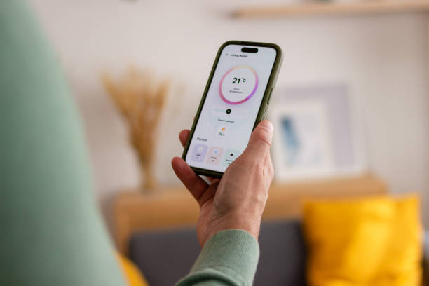 istock Person holding smartphone with smart home app 2150101599