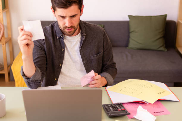 istock Man reviewing finances with concern at home 2150101698