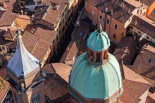 A high-angle shot of Bologna city center, highlighting the Church of Saints Bartholomew and Cajetan, surrounded by historic buildings and narrow streets