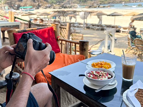 Stock photo showing a close-up view of a behind the scenes food photography of healthy smoothie bowl breakfast served at in an al fresco dining area of a beach restaurant.