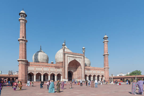 Panoramic image of Jama Masjid Mosque in Old Delhi, the largest mosque in India, with tourists visiting with women wearing suitable clothing to visit the religious site