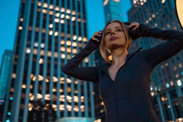 Woman with headphones on urban backdrop