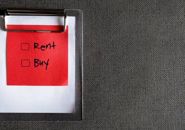 istock Black pencil and red paper note clipping with clipboard on dark copy space background, with text checkbox to choose betwen  RENT and BUY , concept of financial decision making to choose between home renting and home buying 2150107099
