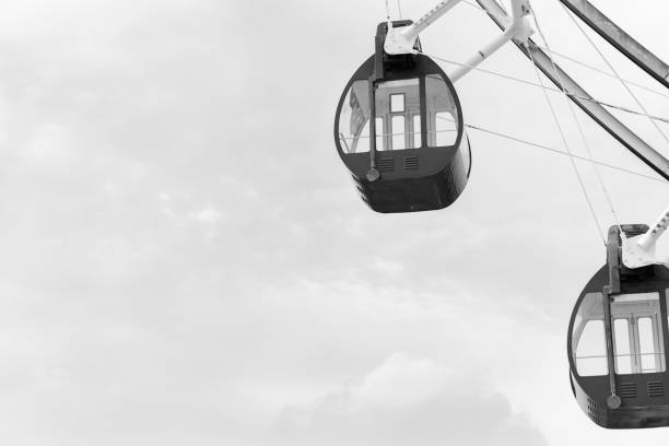Close up black and white Ferris Wheel on amusement park with cloud background