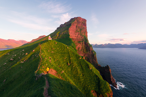Kallur lighthouse on green hills of Kalsoy island, Faroe islands, Denmark. Landscape photography
