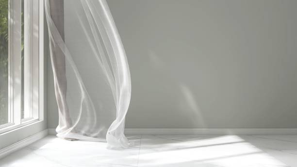 istock Empty pastel green wall room in sunlight from window, blowing white sheer curtain, tree shadow on baseboard, marble tile floor 2150111057