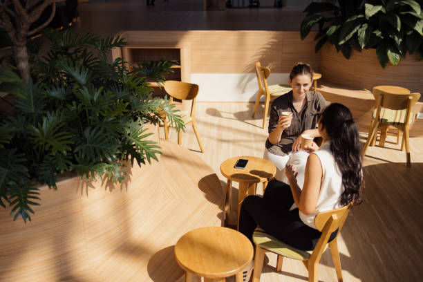 istock Smiling female friends talking in cafeteria. 2150112190