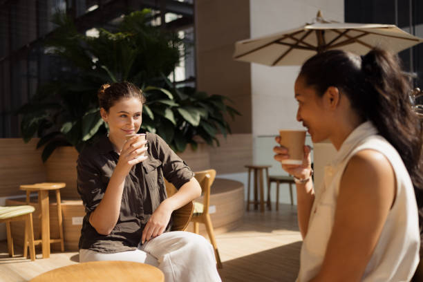 istock Smiling women drinking coffee in cafeteria. 2150112226