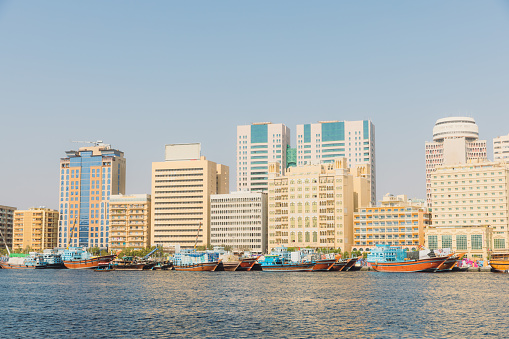 View of Dubai skyline with taxi boats on the water at the Old Town