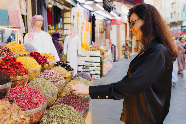 Woman Shopping at Spice and Dyes Market in Dubai City Female in black casual clothes walking the old souk buying spices and dyes at Al Bastakya district of Dubai city, United Arab Emirates arabian sunglasses stock pictures, royalty-free photos & images