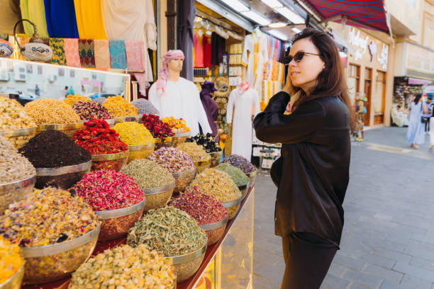 Woman Shopping at Spice and Dyes Market in Dubai City Female in black casual clothes walking the old souk buying spices and dyes at Al Bastakya district of Dubai city, United Arab Emirates arabian sunglasses stock pictures, royalty-free photos & images