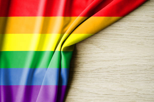 istock rainbow flag or LGBTQ, with a wooden background and copy space for text. 3d illustration. 2150116002
