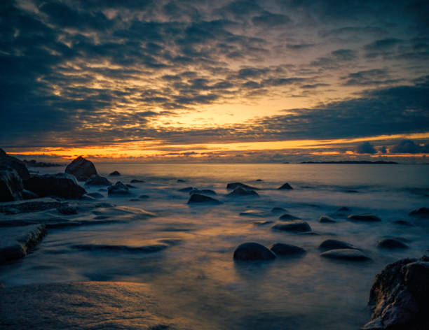 Sunset on rocky beach.