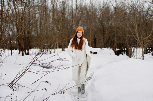 Happy young woman red hair walk in the fresh winter air Walk in the winter forest. High quality photo