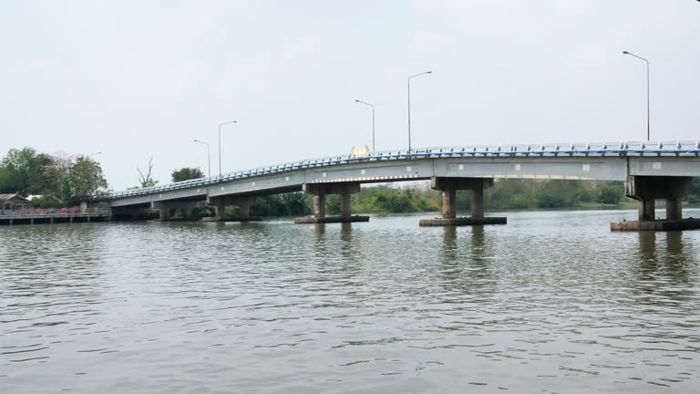 Some vehicles crossing over a bridge located at a fishing village in the outskirts of Bangkok, Thailand.