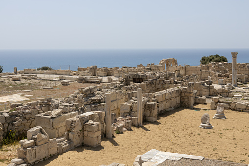 Extensive ruins of Kourion, with columns and remnants of ancient structures, set against the Mediterranean Sea.