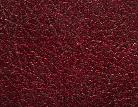 Flat close-up of 100-year-old maroon leather for use as a textured background.