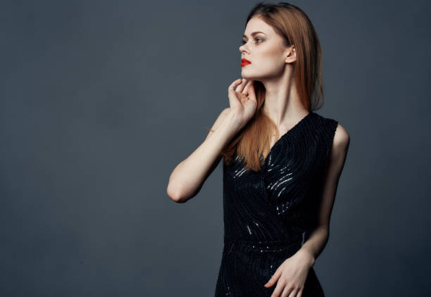 istock Red-haired lady in a dress on a gray background gestures with her hands Copy Space 2150121476