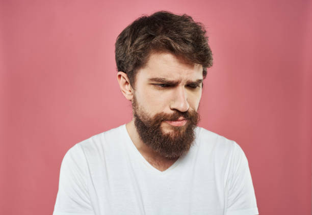 istock Man emotions sadness white t-shirt pink background 2150123871