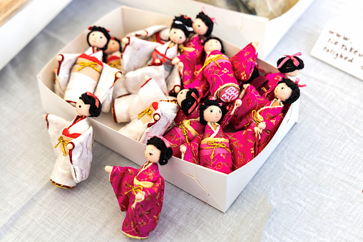 Small Japanese dolls in traditional Japanese clothes in a box. Japanese souvenirs. Copenhagen, Denmark - April 21, 2024