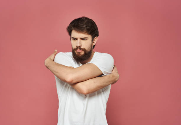 istock Sad man crossed his arms over his chest on a pink background 2150124093