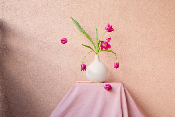 istock tulips in vase on table on background wall 2150124405