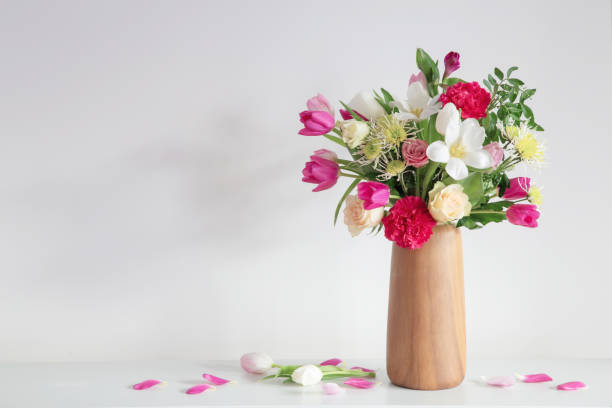 istock beautiful flowers  in vase on shelf  on background white wall 2150124417