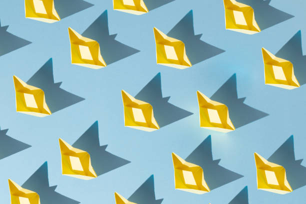 istock yellow paper boats on blue background 2150124421