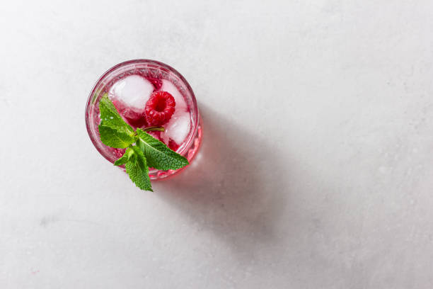 istock Raspberry drink with ice in a glass on a light background 2150129029