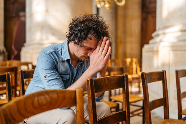istock Young Man Praying In The Church In Paris 2150129082
