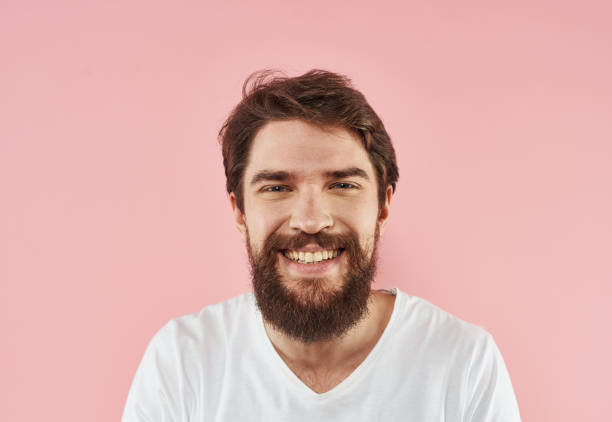 istock Bearded man on a pink background gesturing with his hands and a white T-shirt cropped view 2150129569