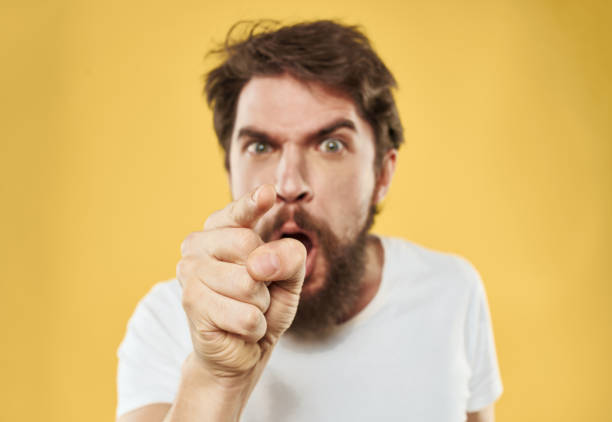 istock A man with a beard gestures with his hands near his face on a yellow background 2150130951