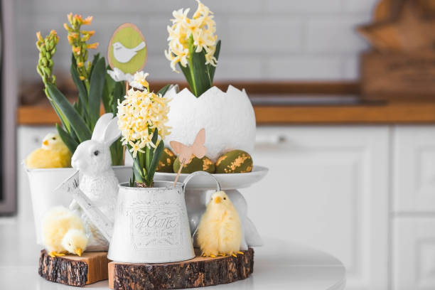 istock Happy Easter. Spring yellow hyacinth flowers in an egg-shaped vase, chicken chicks on a white table. In the background is a white Scandinavian-style kitchen. Easter decor in the house. 2150131937