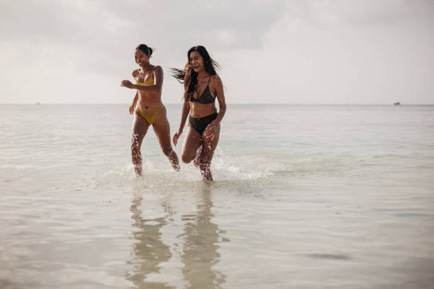 istock Friends running by the sea 2150132160