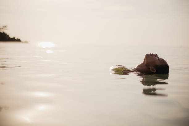 A young woman enjoys a summer day in the sea.