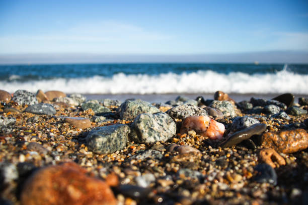 Llevant beach on the Balearic sea, Barcelona, Spain, on a sunny day, waves and sea, blue sky, sand, pebbles and rocks, summer vibes