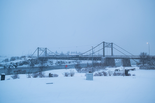 Selfoss suspension bridge across over the river in snowstorm or blizzard on wintertime at Iceland