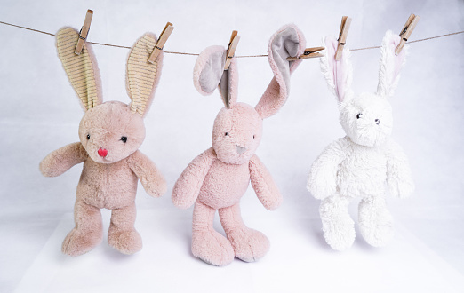 Toy hares hanging on a rope on clothespins