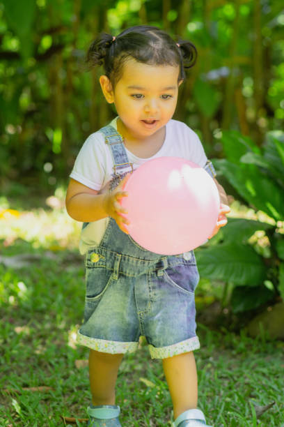Little girl in joyful moments in her yard. Lots of fun and joy amidst lots of plants, flowers and nature.