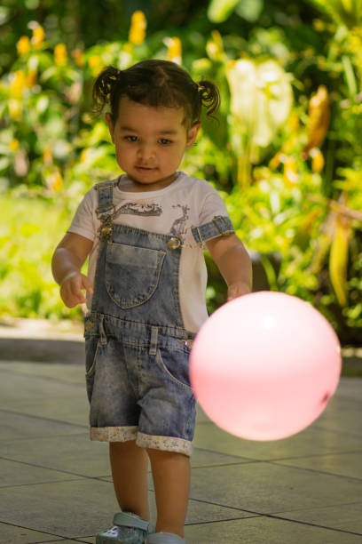 istock Little girl playing with her pink ball. 2150135171