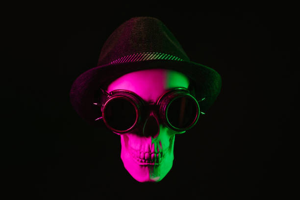 human skull in steampunk glasses and a hat with a pink green light on a dark background